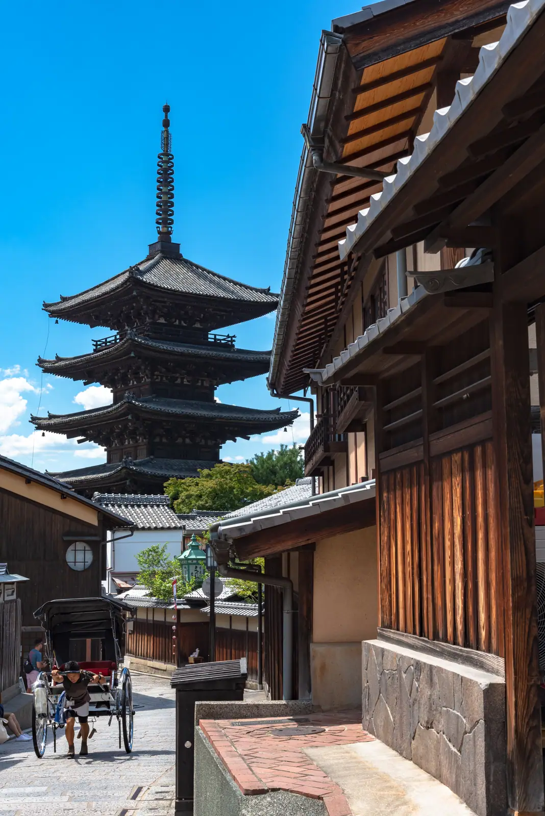 A five-storey pagoda above the wooden houses of a Kyoto street