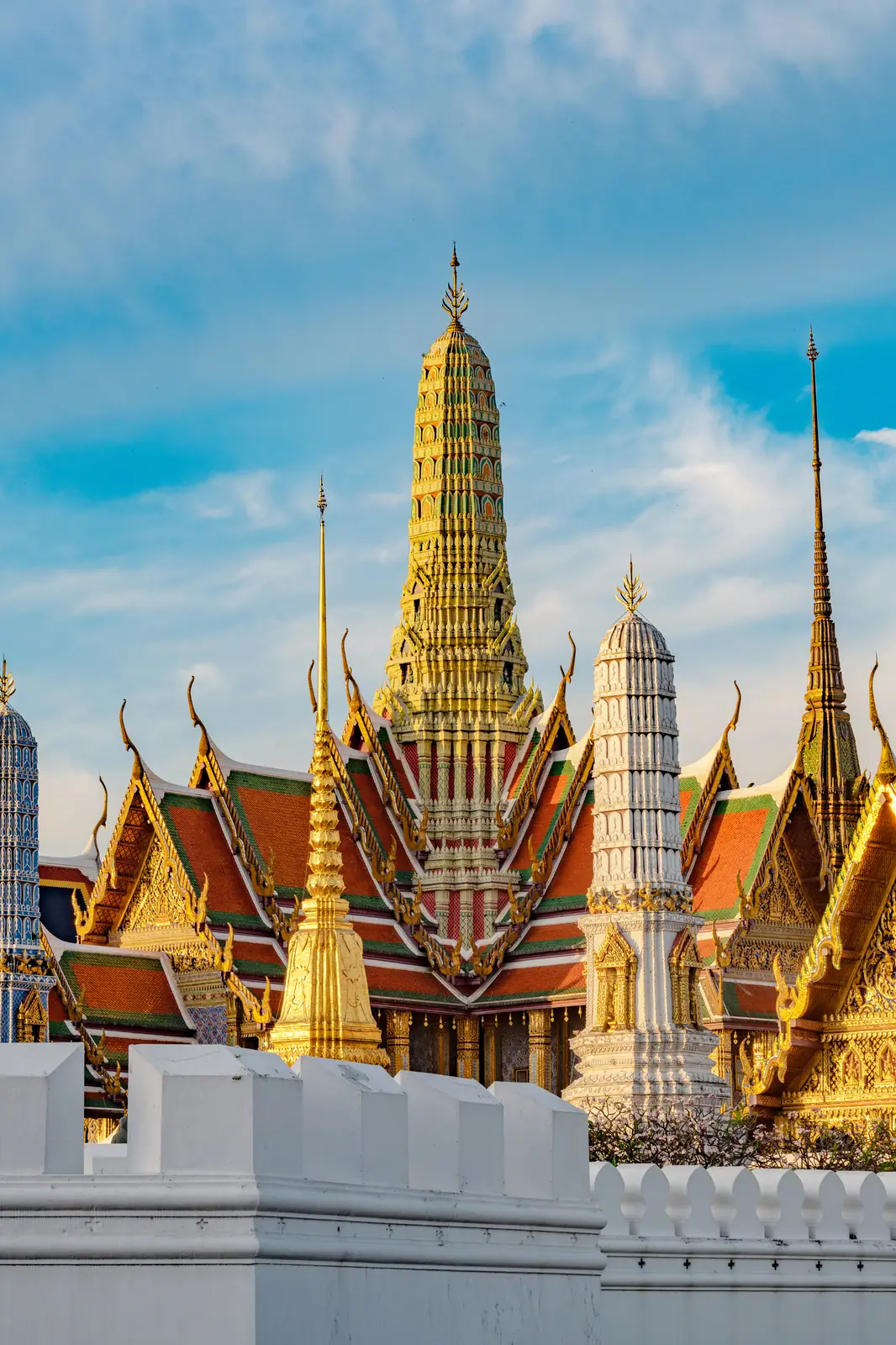 Gilded spires of the Grand Palace in Bangkok under a blue sky